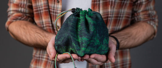 DnD gift ideas for players and Dungeon Masters, featuring dice bags with pockets and compact dice trays arranged on a tabletop gaming table
