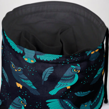 Close-up of the owl print — teal owls, feathers and stars on dark navy gabardine.