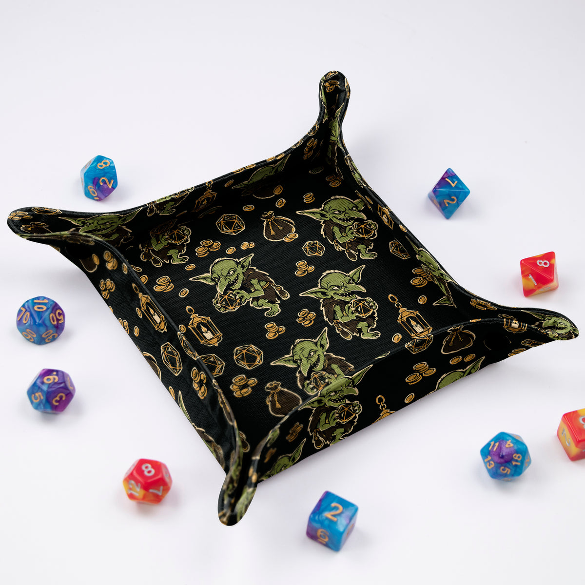 Dice Goblin Hoard tray at an angle, black fabric with green goblins holding d20s, gold coins and loot pouches, snap corners and colorful dice