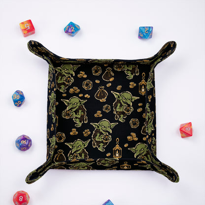 Goblin dice tray from above, black print with goblins, lanterns, gold coin stacks and treasure pouches