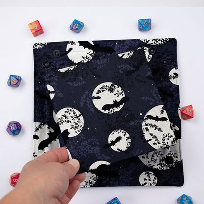 Bat and Full Moon dice tray folded flat, hand lifting the removable hard insert covered in the same print