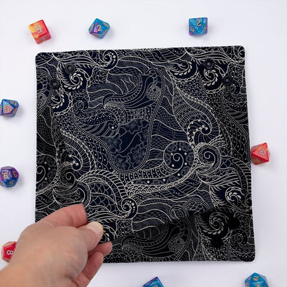 Dragon Scale dice tray folded flat, hand lifting the removable hard insert covered in the same scale print