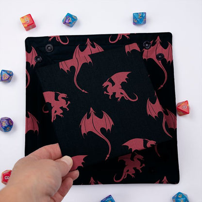 Red Dragon dice tray folded flat, hand lifting the removable hard insert covered in the same dragon print