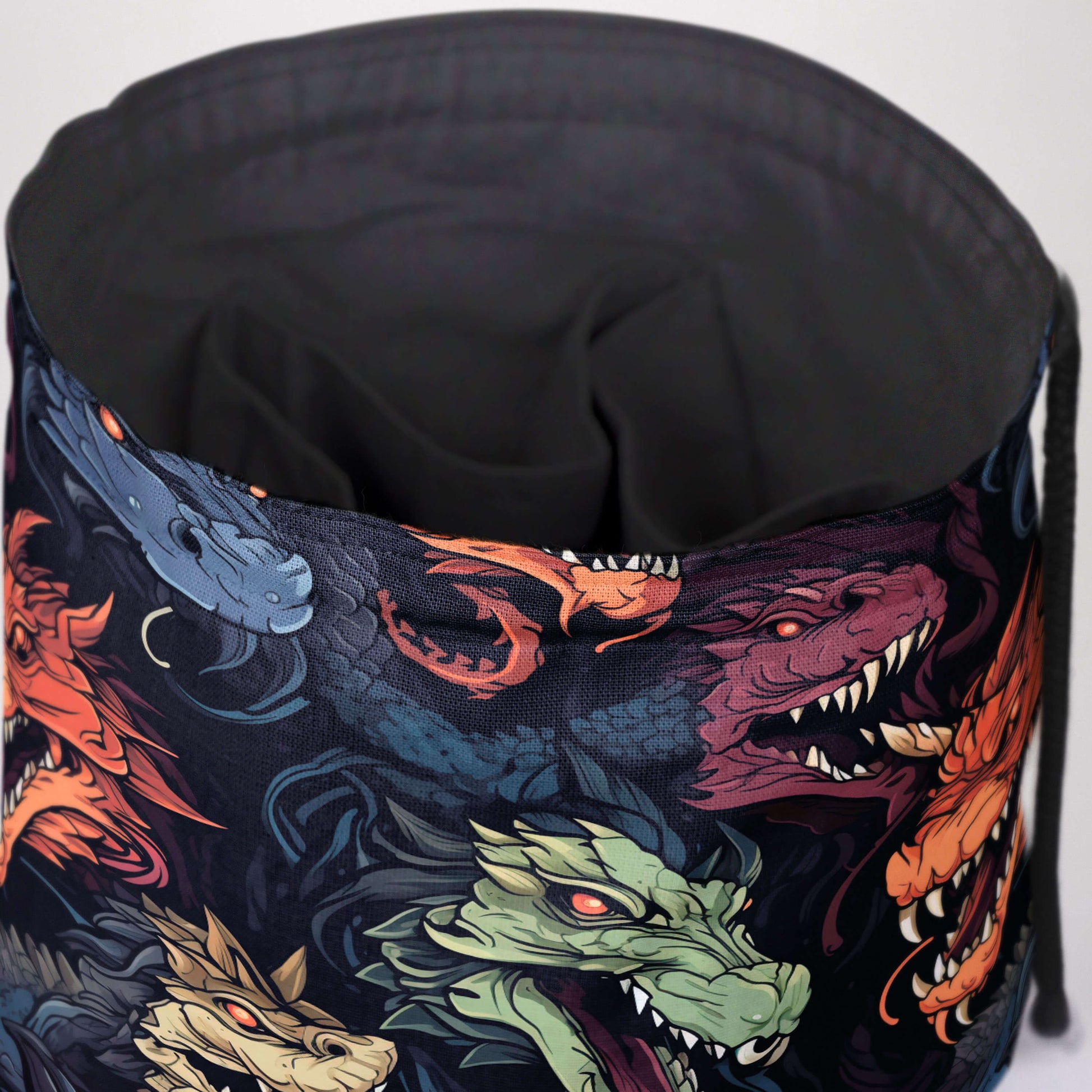 Close-up of the chromatic dragon-head artwork — vivid dragon faces on black fabric.