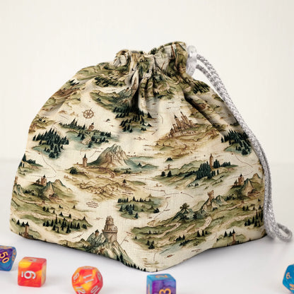 Close-up of the fantasy map print — mountains, forests and compass roses on cream gabardine.
