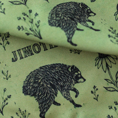 Close-up of GameFancy Jimothy raccoon print fabric, sage botanical design, used for handmade dice bags