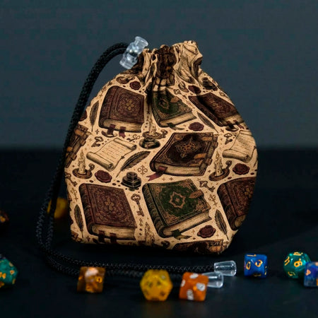 Ancient Spellbooks dice bag with drawstring gathered, tan fabric printed with ornate leather tomes, scrolls and candles