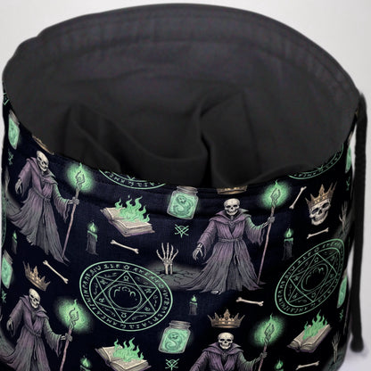 Necromancer dice bag print detail — skulls with gold crowns, ritual circles, potion jars