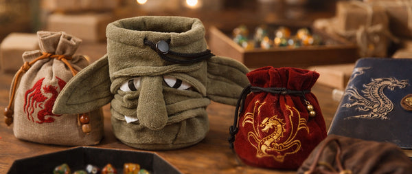 D&D gift guide 2026: a plush goblin dice bag and dragon dice bags on a gaming table