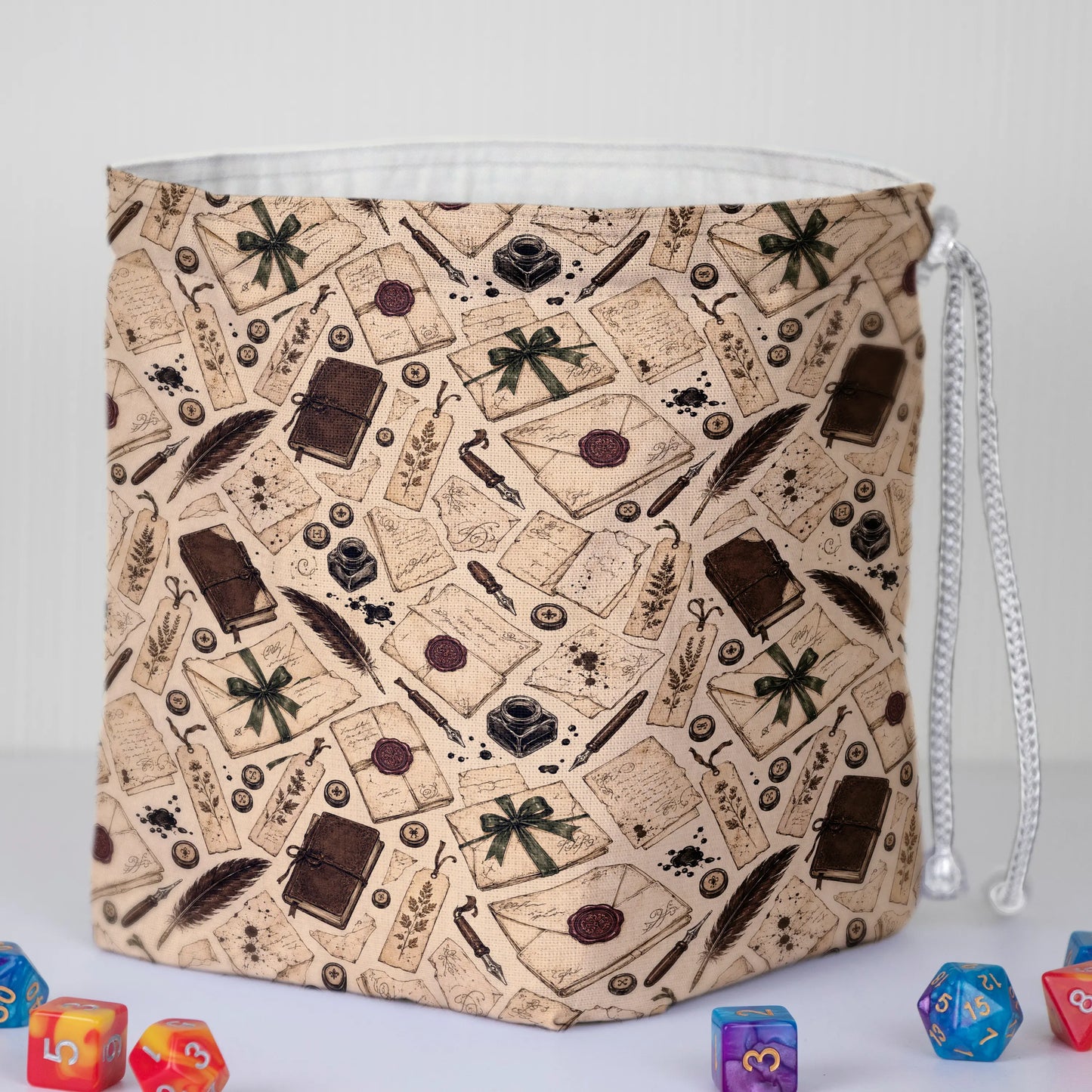Handmade letter-print dice bag — quills, books and ribbons on cream, a 6-pocket dark academia organizer.