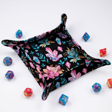 Crystal Witch dice tray at an angle, pink and teal crystals with roses on black fabric, colorful dice around it