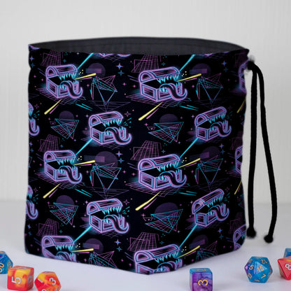 Neon mimic dice bag held in hand — purple and cyan wireframe mimic print, drawstring closure