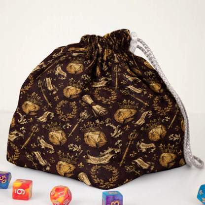 Brown Dungeon Master crest dice bag held in hand — handmade gabardine DnD organizer.
