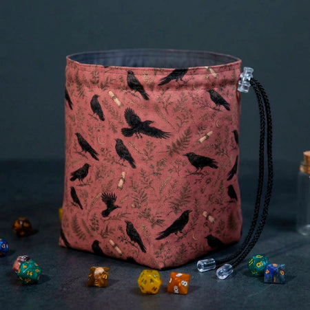 Fernwood Corvus dice bag standing open, terracotta fabric with black crows, ferns and gold crescent moons, dice around the base