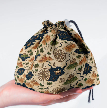 Voyager's Map dice bag held in hand — handmade cartographer DnD organizer.