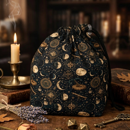 A dark academia dice bag for your aesthetic — gold moons, constellations and astrolabes on midnight navy, holds 300+ dice.