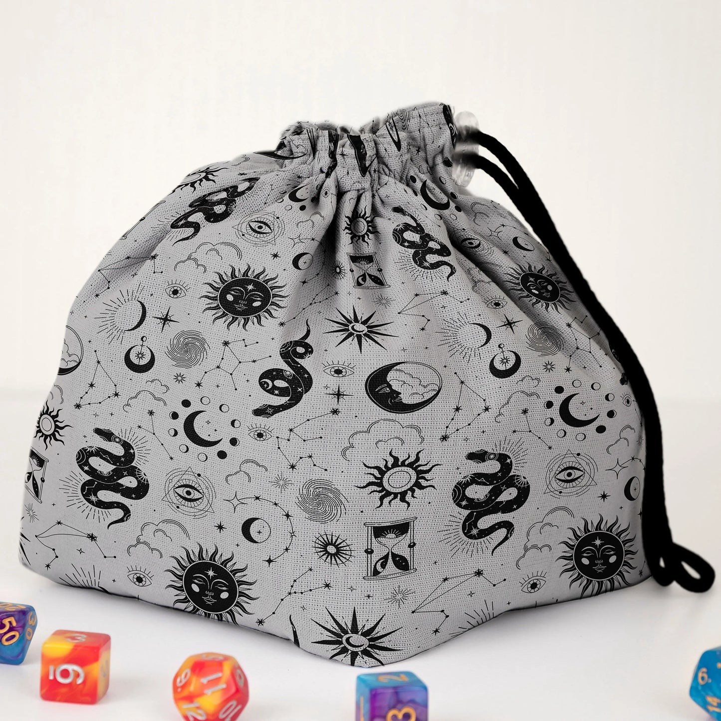 Close-up of the celestial serpent print — snakes, constellations, suns and eyes on gray gabardine.