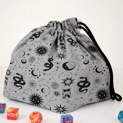 Close-up of the celestial serpent print — snakes, constellations, suns and eyes on gray gabardine.