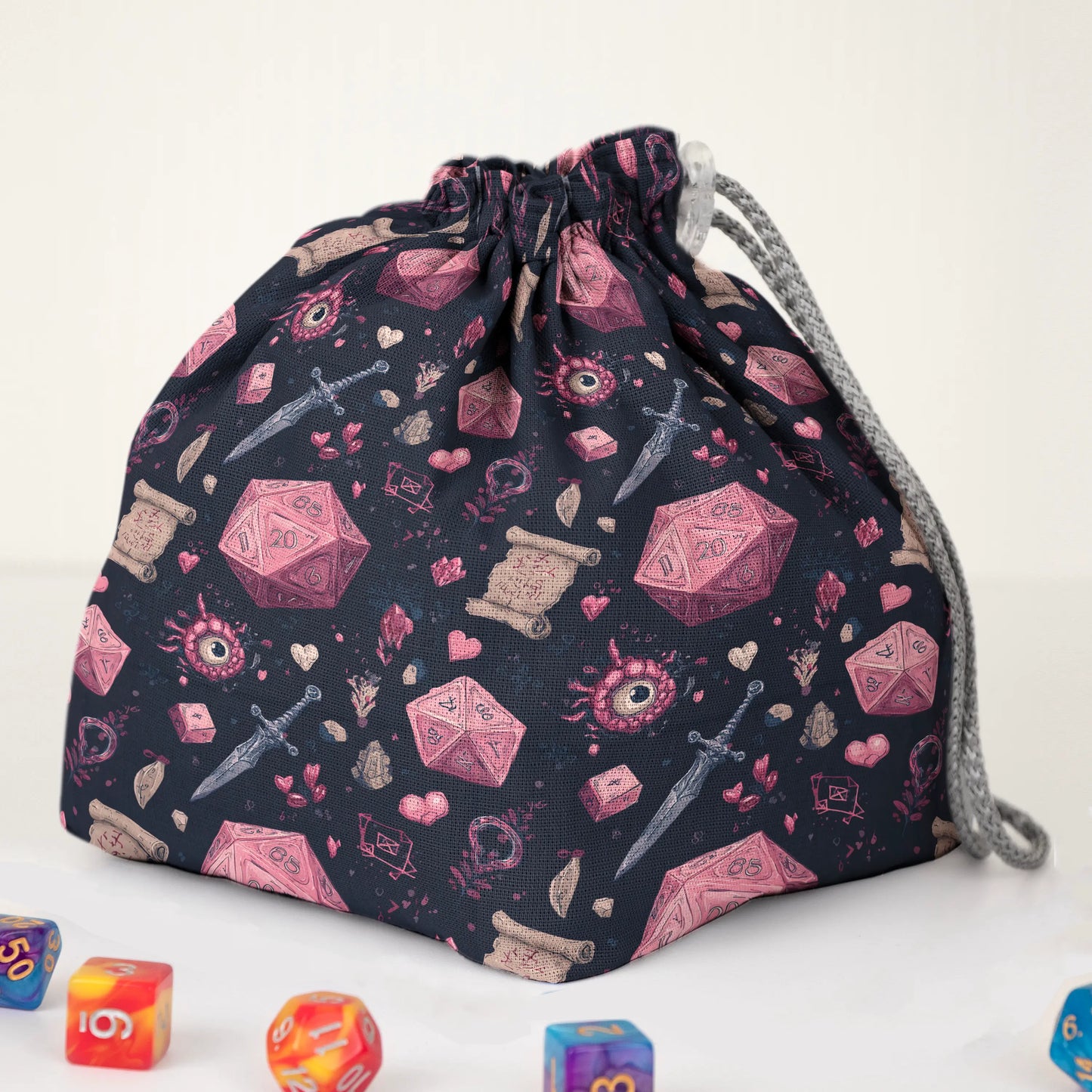 Close-up of the crimson D20 print — red-pink dice, hearts and daggers on black gabardine.
