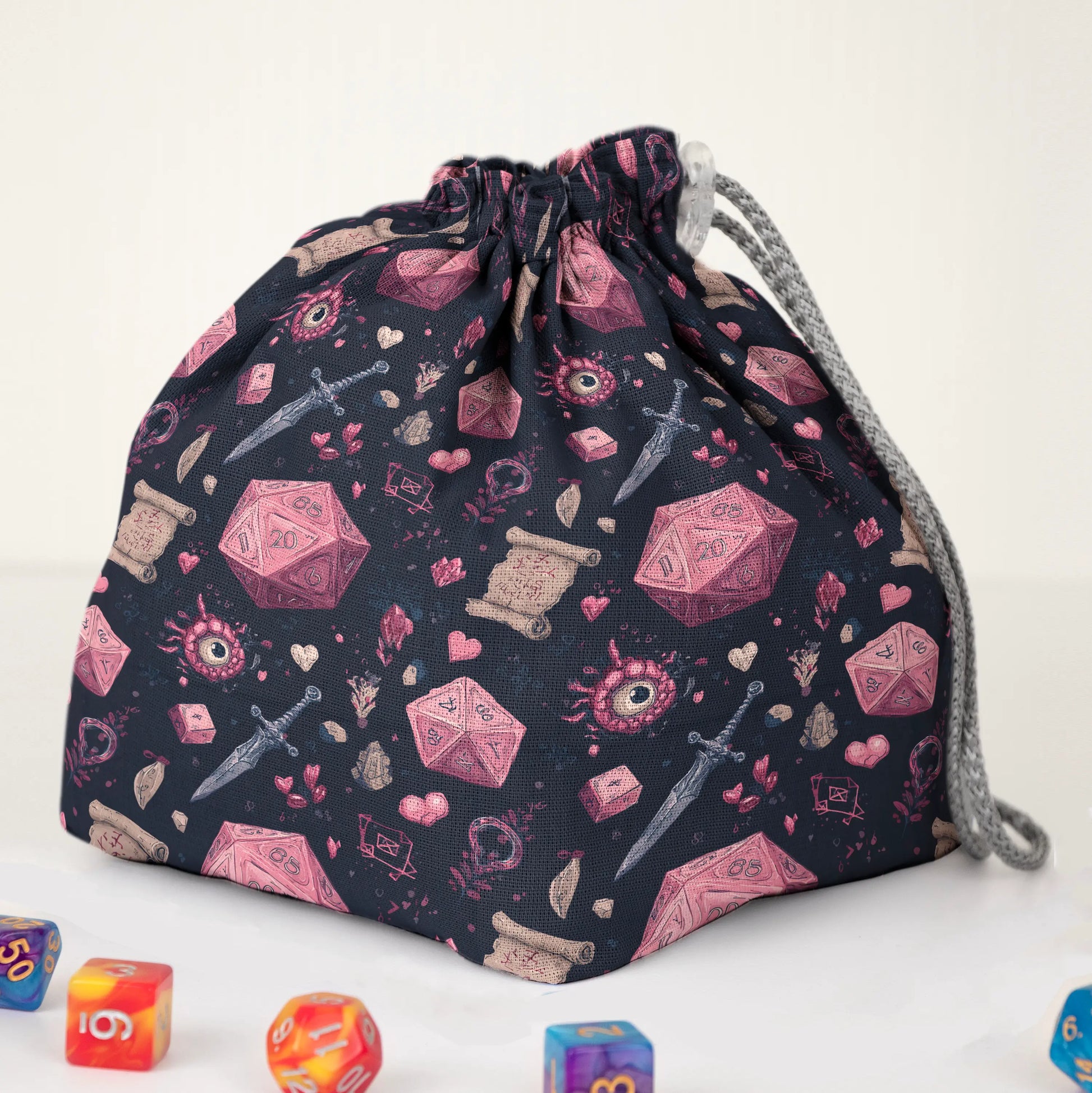 Close-up of the crimson D20 print — red-pink dice, hearts and daggers on black gabardine.