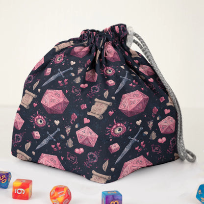 Close-up of the crimson D20 print — red-pink dice, hearts and daggers on black gabardine.
