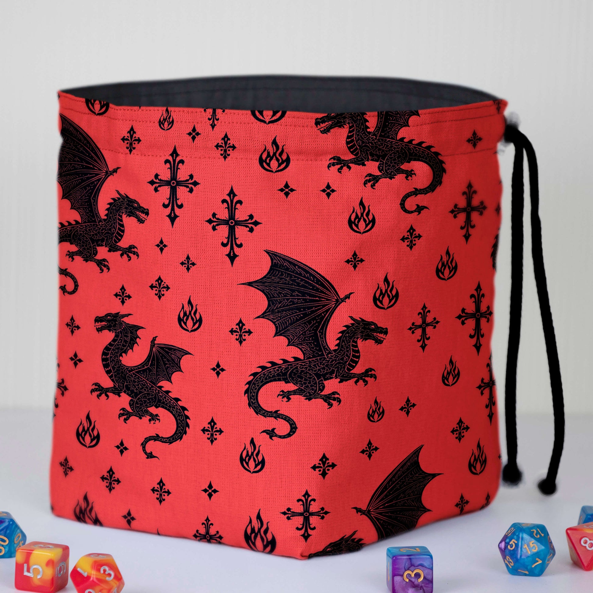 Red dragon dice bag front view — black flying dragons and flame motifs, black drawstring.