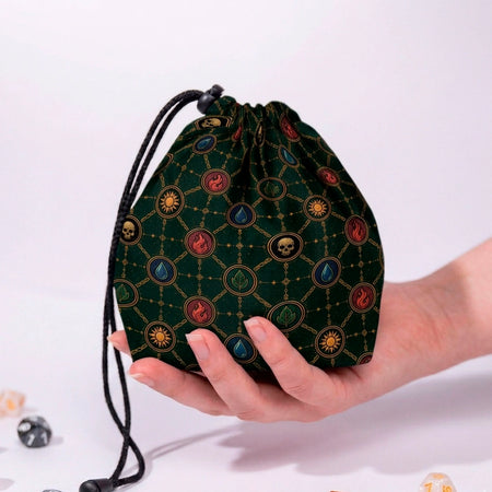 MTG commander dice bag with five mana element medallions in gold chains on emerald green, held in a hand