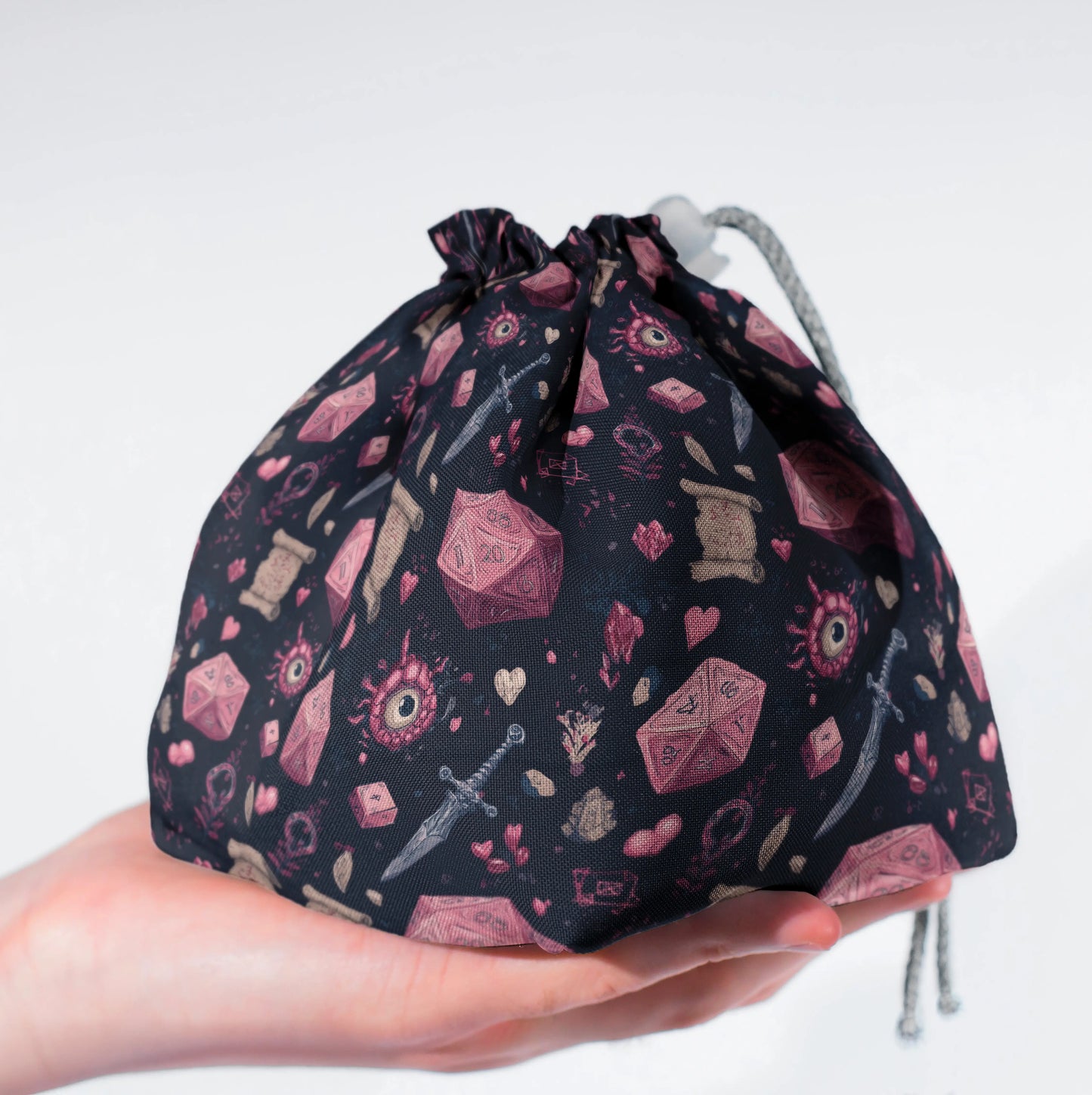Crimson D20 dice bag held in hand — handmade DnD organizer with pockets.
