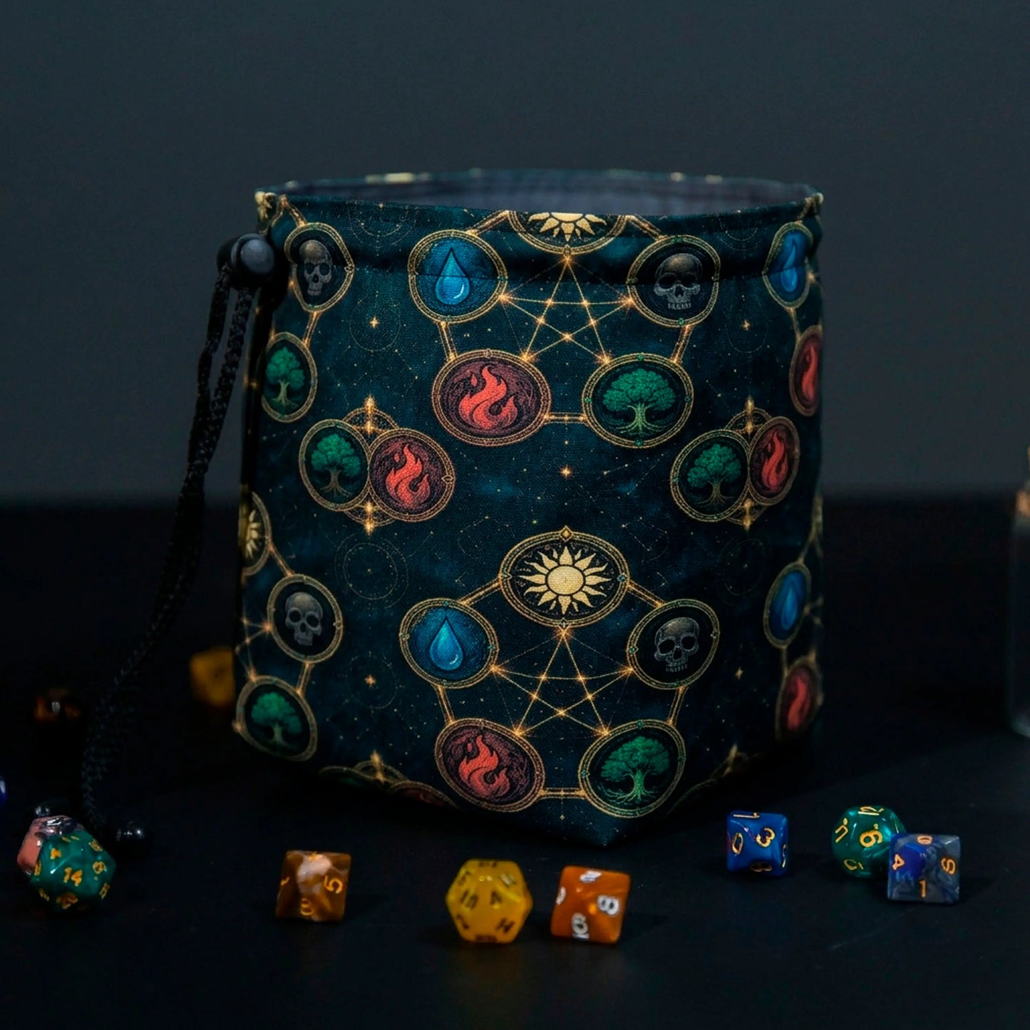 MTG dice bag with five mana element medallions linked by gold constellations on dark teal, standing open with dice