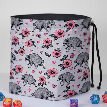 Pink Blossom Jimothy dice bag standing open on its square base with dark lining, raccoons and hearts print