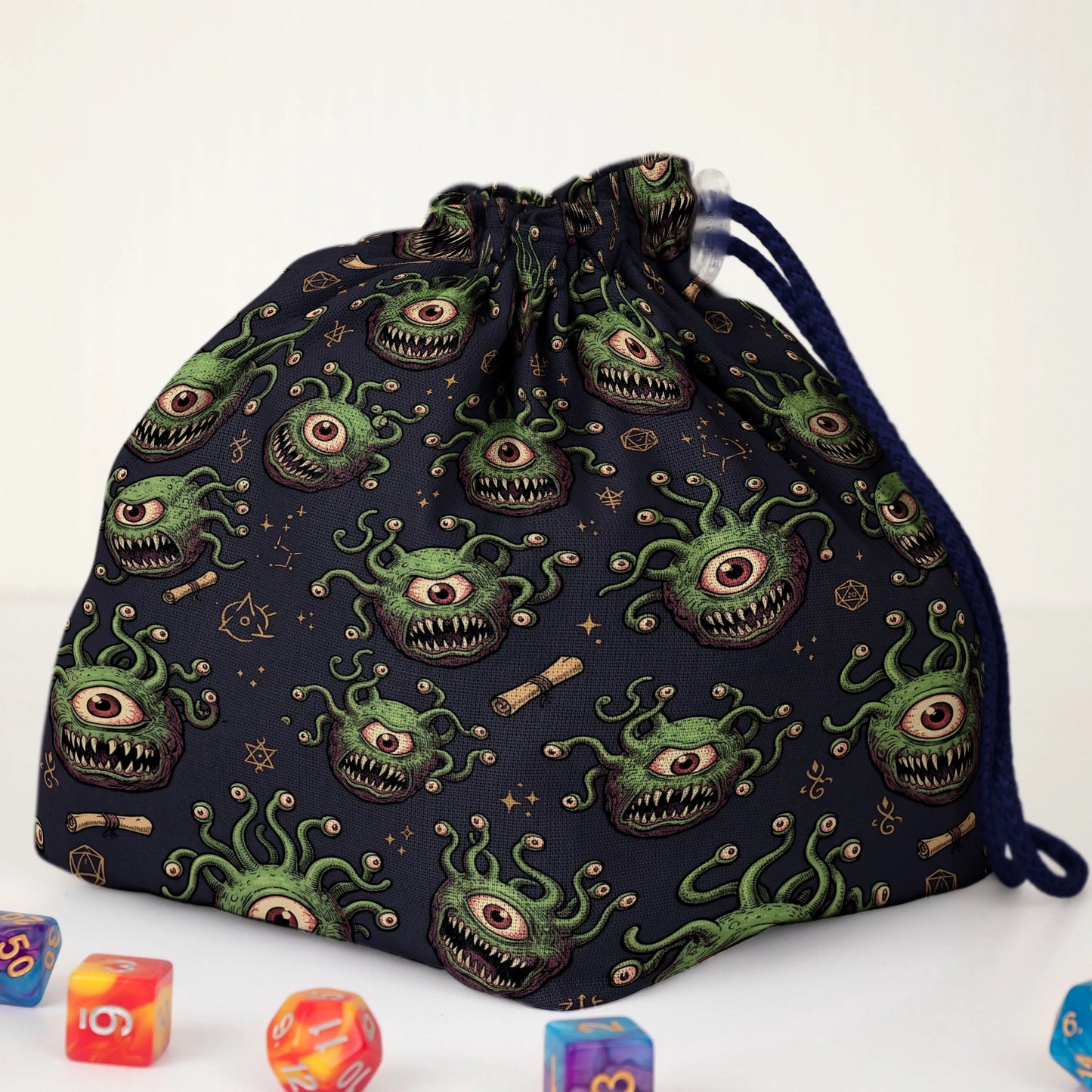 Beholder dice bag print detail — green one-eyed monsters with teeth on navy fabric
