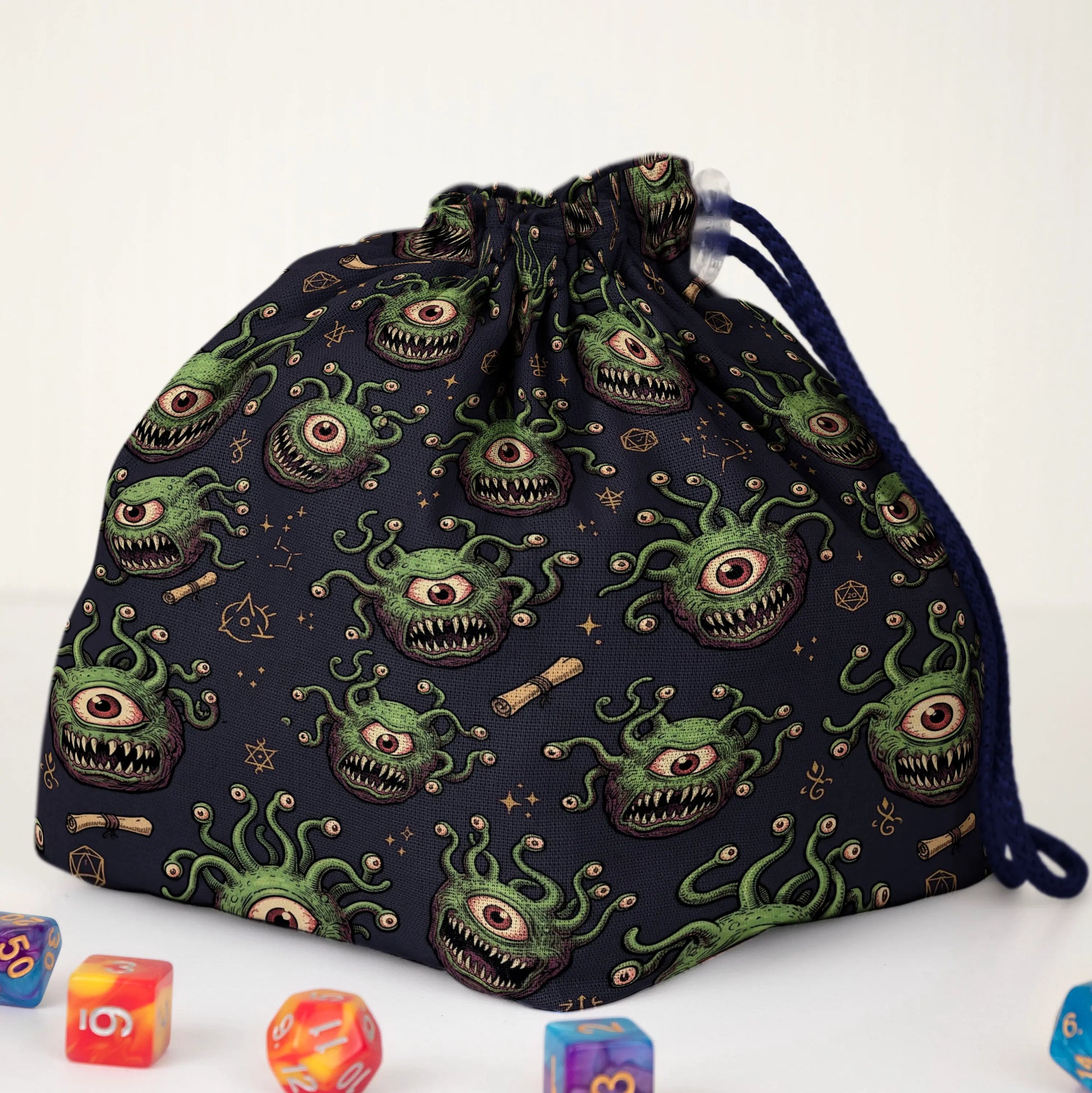 Beholder dice bag print detail — green one-eyed monsters with teeth on navy fabric