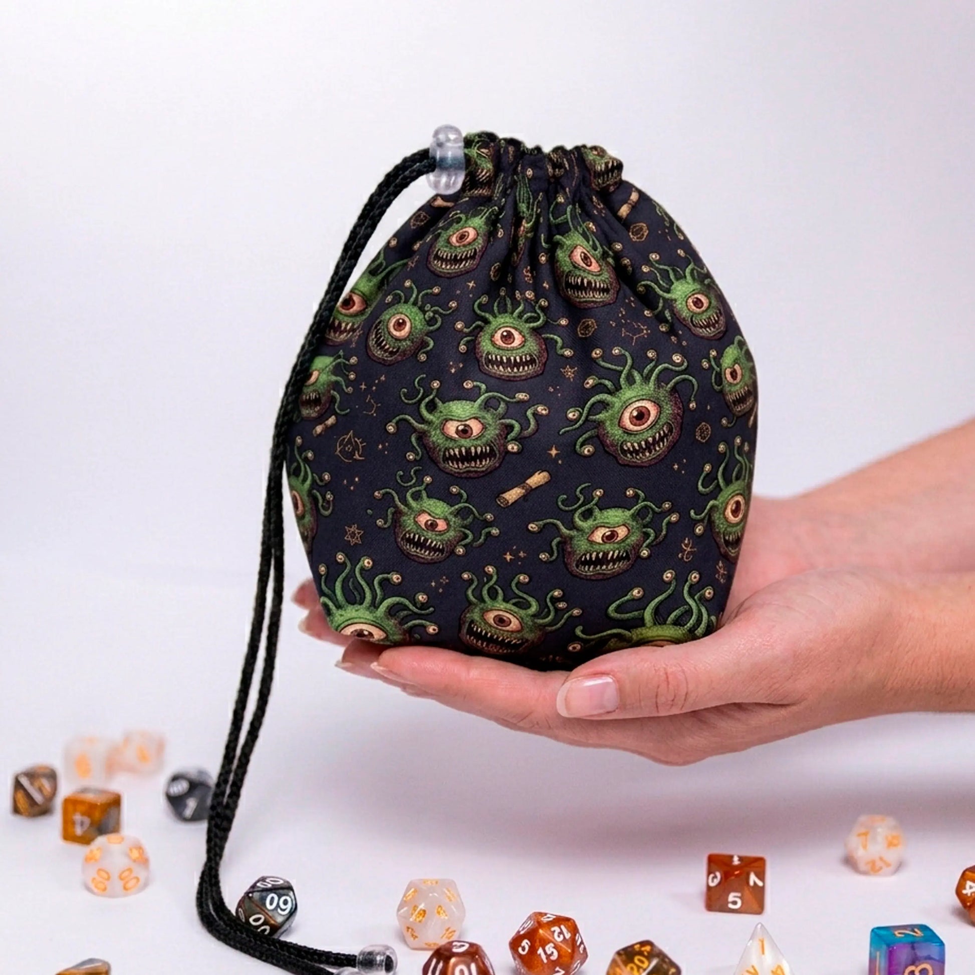 Green beholder dice bag — grinning eye tyrants with eyestalks on dark navy, holds 300+ dice