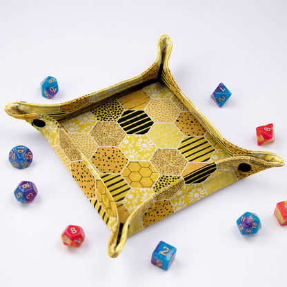 A cottagecore dice tray — golden honeycomb hexagons and daisies, foldable 5.5-inch rolling surface.