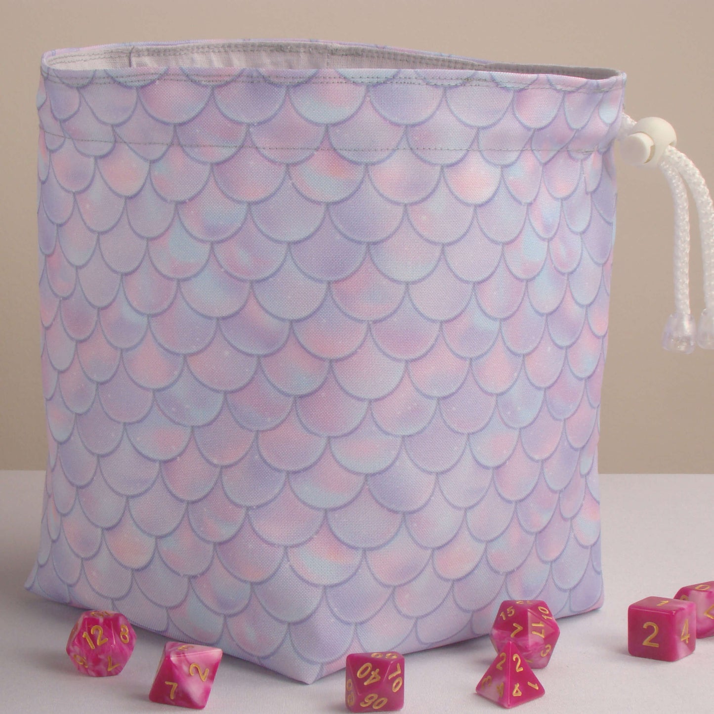 Close-up of the pastel dragon-scale print — pink and lavender gabardine fabric.