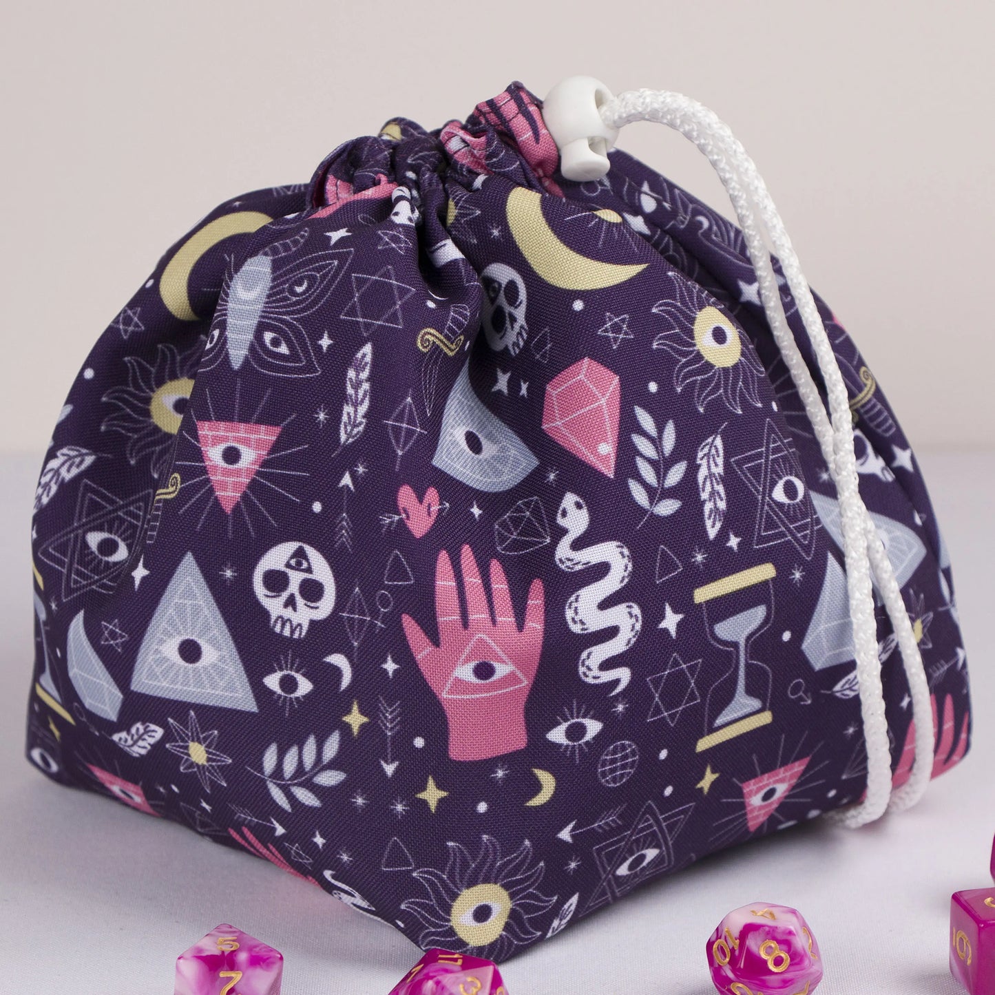 A dice bag that matches your witchy aesthetic — palmistry hand, all-seeing eyes and crystals on deep purple, holds 300+ dice.