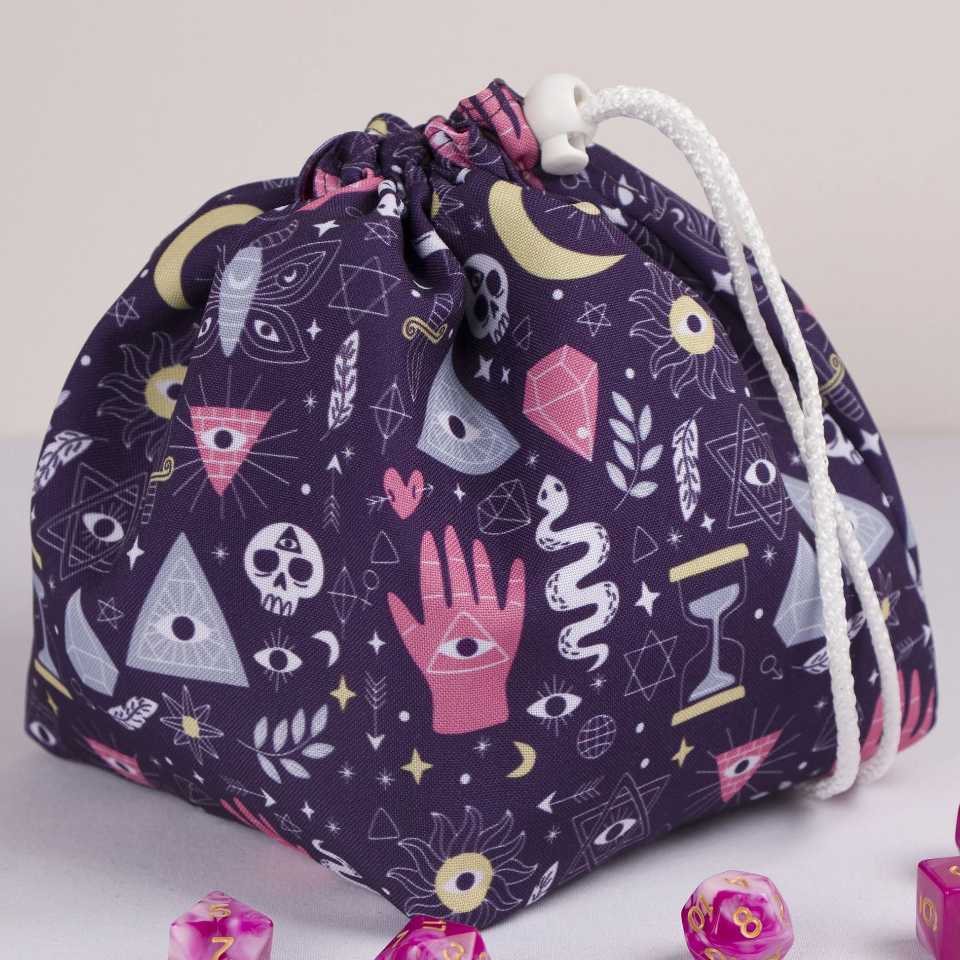 A dice bag that matches your witchy aesthetic — palmistry hand, all-seeing eyes and crystals on deep purple, holds 300+ dice.