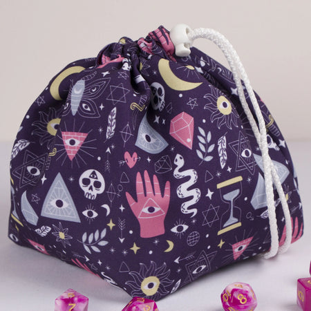 A dice bag that matches your witchy aesthetic — palmistry hand, all-seeing eyes and crystals on deep purple, holds 300+ dice.