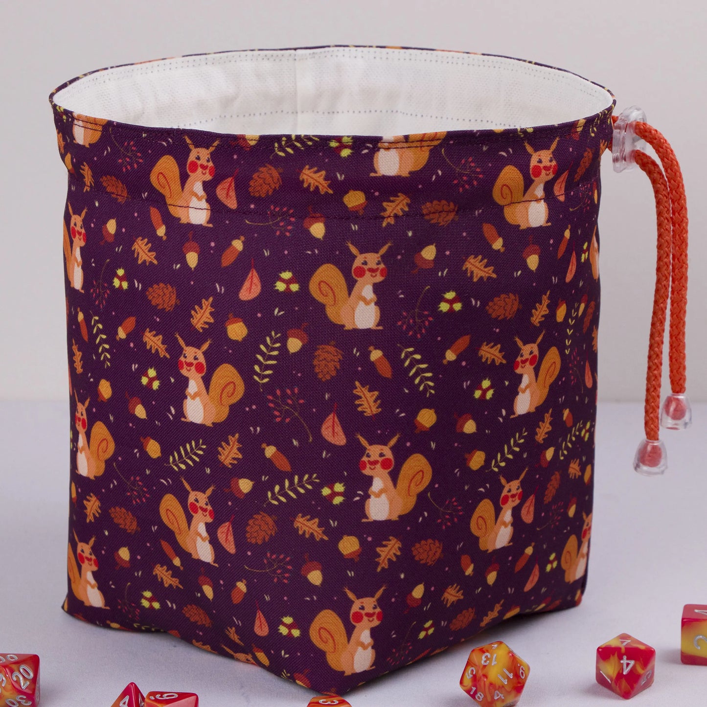Handmade woodland dice bag — squirrels and pinecones on purple, a 6-pocket cottagecore organizer.