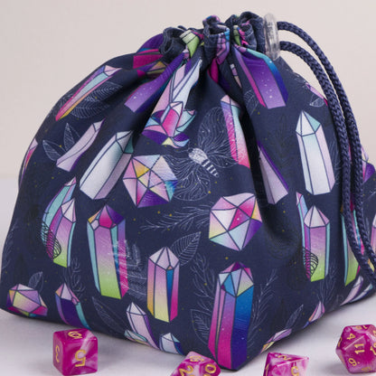 A dice bag that matches your witchy aesthetic — iridescent rainbow crystals and moths on navy, holds 300+ dice.