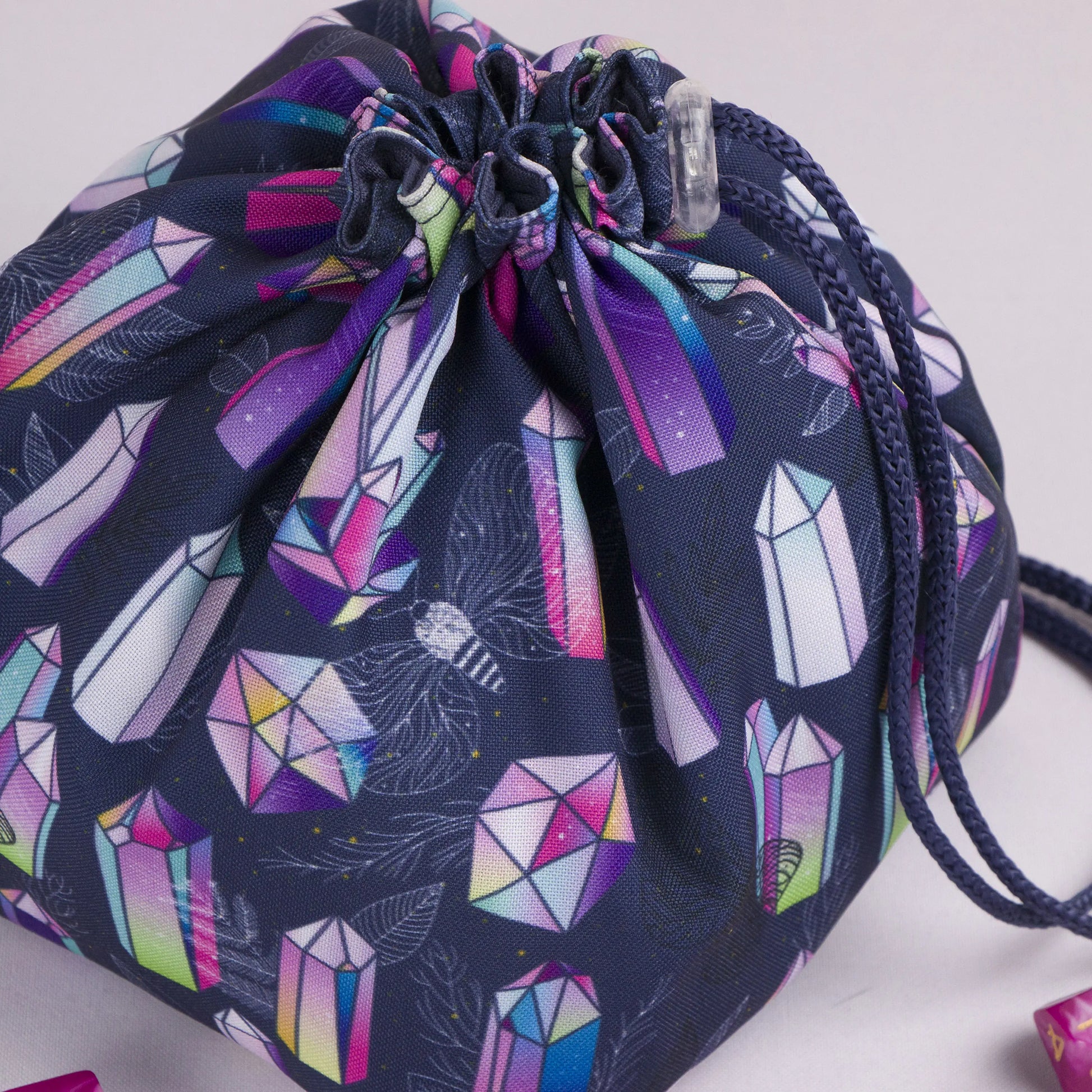 Close-up of the rainbow crystal print — iridescent gemstones and moths on navy gabardine.