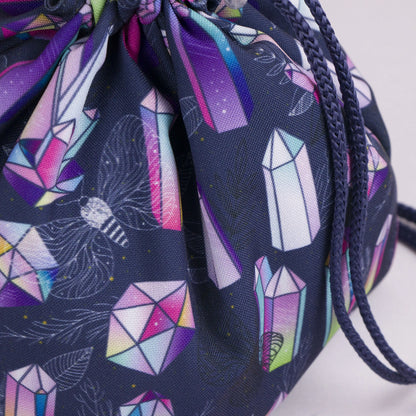 Rainbow crystal dice bag held in hand — handmade witchy gabardine DnD organizer.